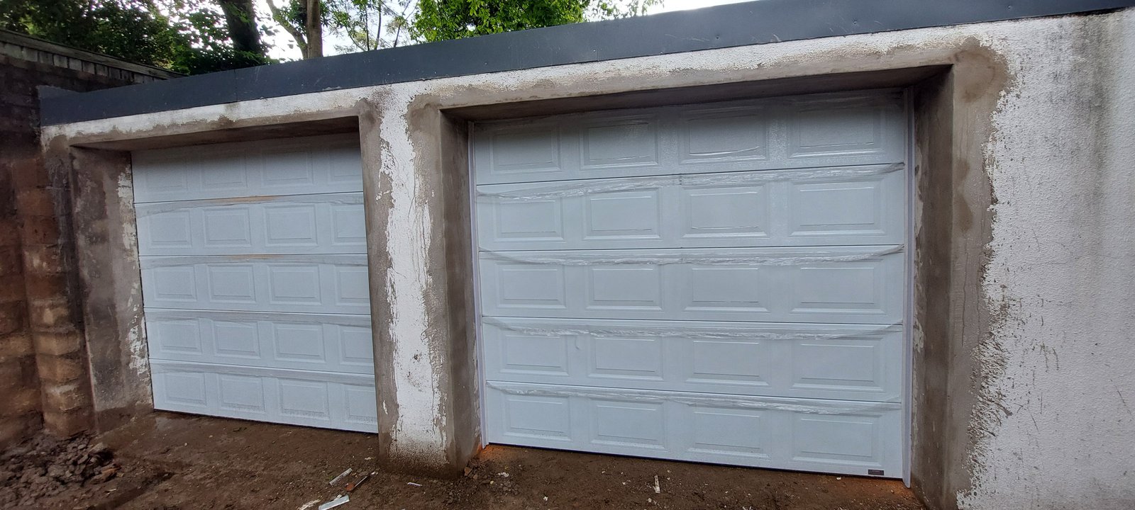 A newly fitted pair of light grey garage doors